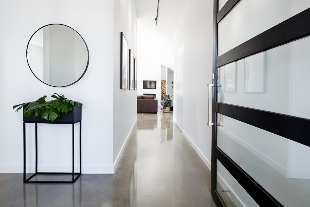 Contemporary home entry hall with polished concrete floors and white walls