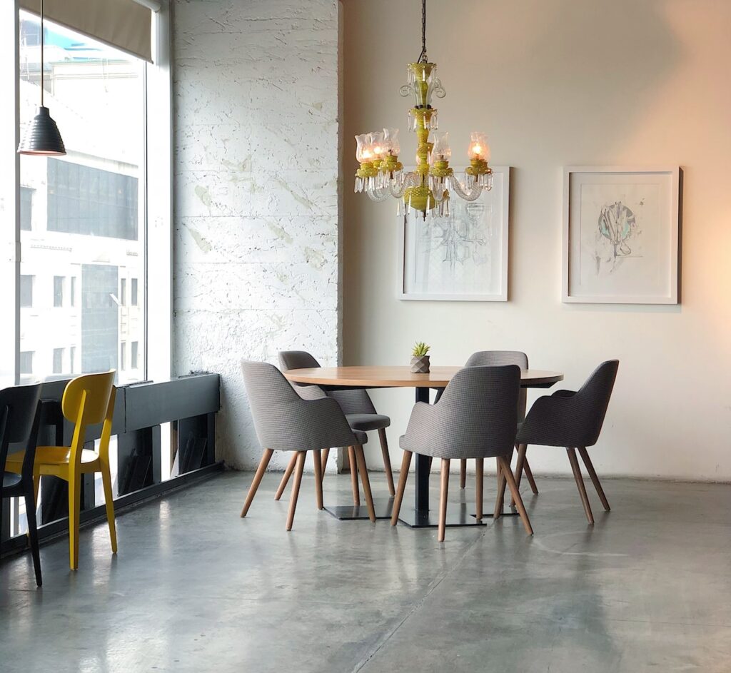 Dining room on a high level floor of a city building, with grey dining chairs, table, and polished concrete floor.